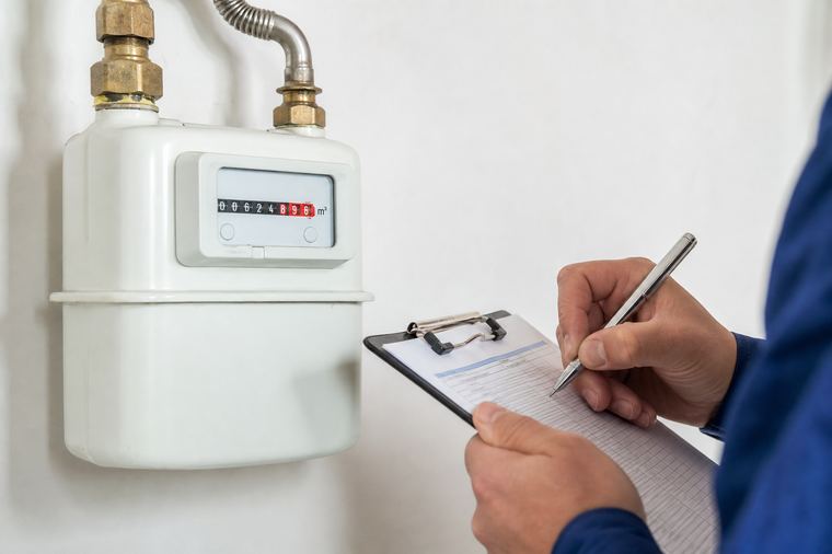 Contatore elettrico grigio fissato al muro, con quadranti e numeri di lettura ben visibili